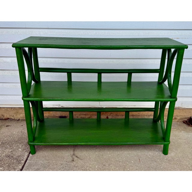 A mid-century two-tier rattan étagère, newly painted in green with layered glazes and a fine fly speckle that give it an...