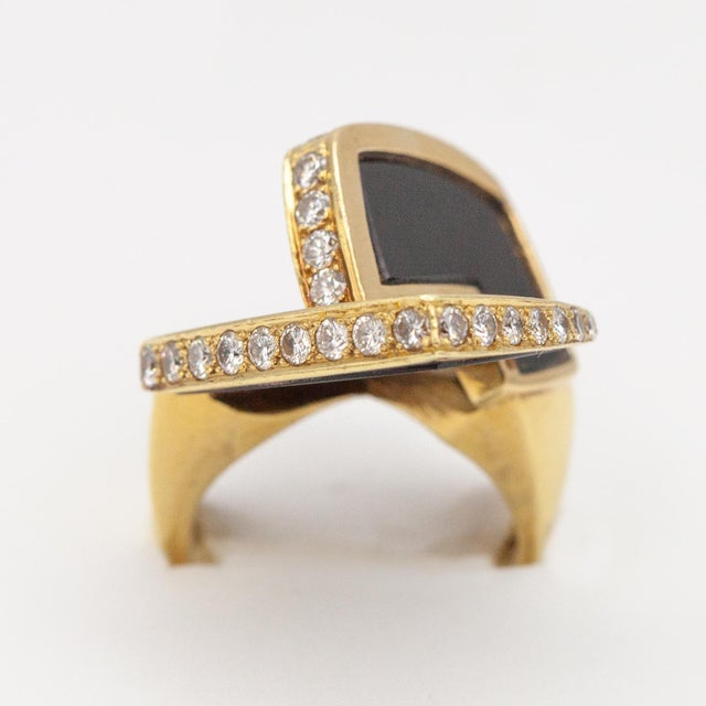 Signed La Triomphe 18K yellow gold diamond onyx cocktail ring set with 28 round brilliant cut diamonds approximate 1.2...
