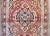 A fantastic early 20th century Vintage Persian Bibikibad rug with a large central floral medallion woven in bold crimson,...