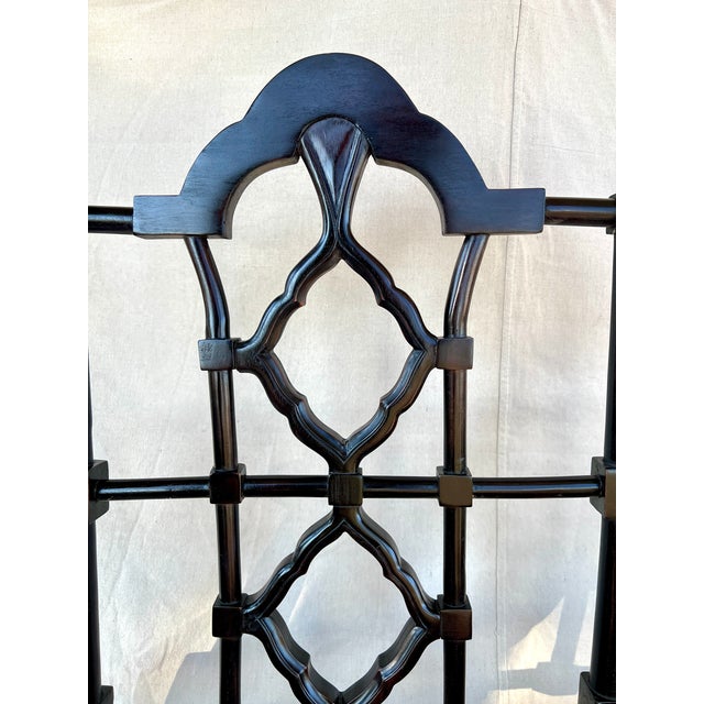 A Chinese Chippendale style ebonized bench with double hand caned seats. Hand carved frame of Philippine mahogany with a...