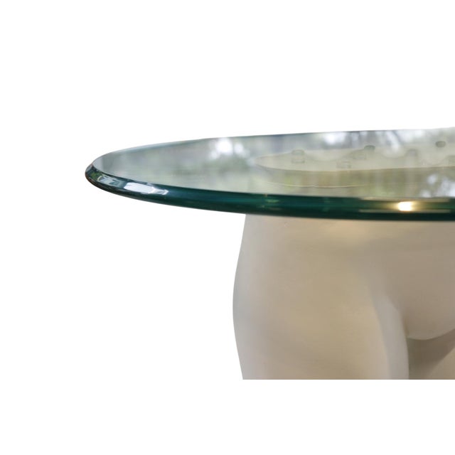 An art piece end table with a round beveled glass table top. Cast mannequin-like legs are finished with real shoes painted...