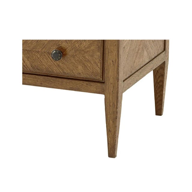 A light oak parquetry chest of drawers in dawn finish. It has mirrored herringbone oak parquetry drawers, classically...