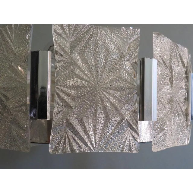 The pendant is provided with panels in frosted acrylic with a graphic motif, the bottom plate has a graphic motif as well....