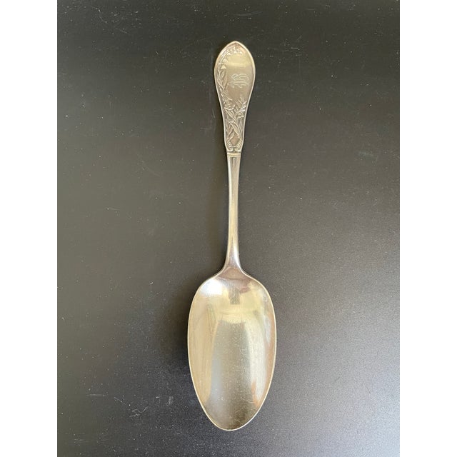 An antique tablespoon/serving spoon in the Lily pattern by 1847 Rogers Bros. This Aesthetic Movement design features...
