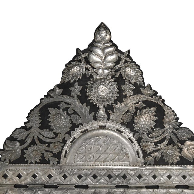 Lofty Spanish Colonial style wall mirror with a dramatic crest decorated in hand hammered tin floral motifs over a...