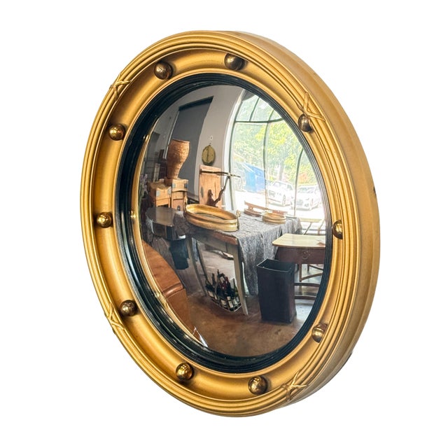 A fine English round or circular convex mirror featuring a Regency design of a moulded gilt frame and ebonized trim, with...