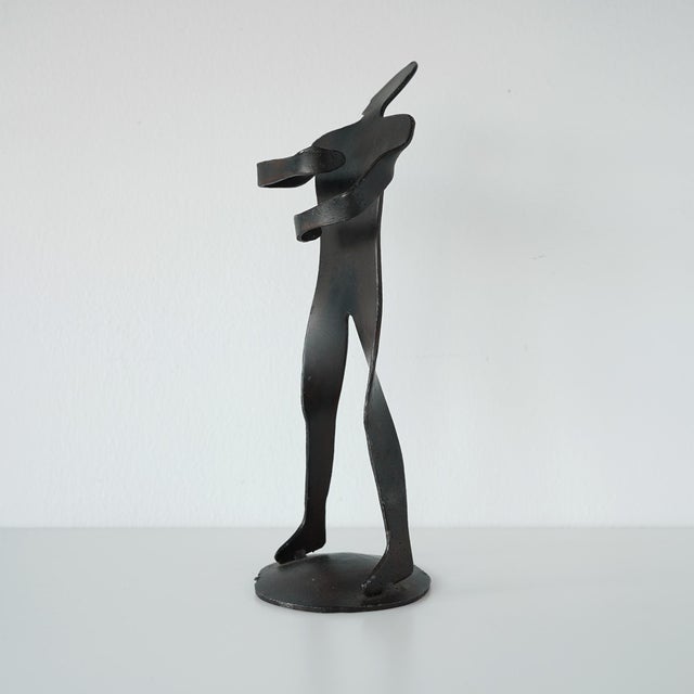Vintage circa 1990s forged iron figure of a man with his arms in a wrapped position. Crafted from a single piece of iron...
