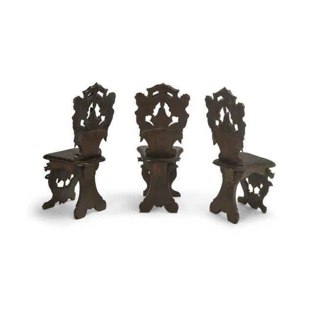 This impressive set of three Renaissance-style hall chairs, crafted in the 19th century, showcases elaborate craftsmanship...