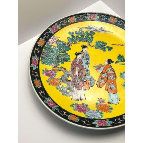 A large Japanese export 15" Chinoiserie-style porcelain charger plate, crafted in Japan around the 1930s. Stamped to its...