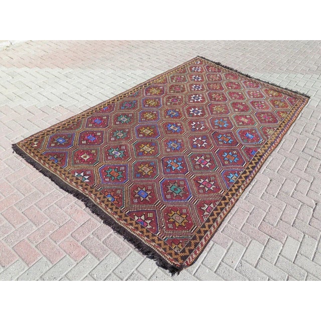 This beautiful, traditional vintage, flatweaved Turkish kilim rug is approximately 60 years old. It is handmade of wool...