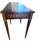 This table's design, featuring a dark wood finish, gold inlay in a chain-link motif, and tapered legs, suggests a piece...