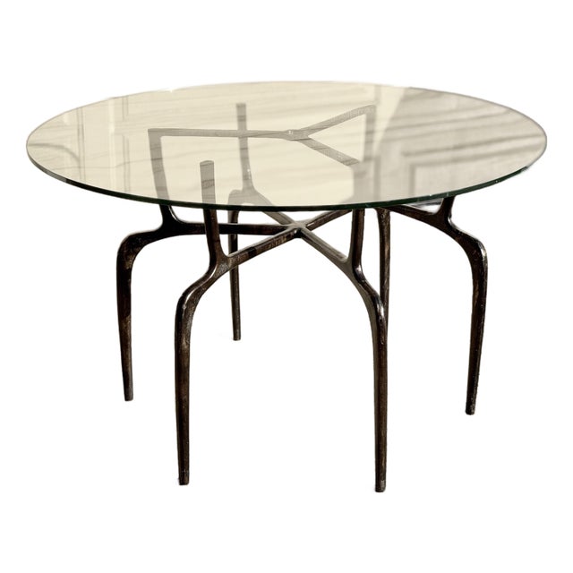 Sculptural Antique Bronzed Iron Legs Round 48” Glass Top Cyrano Dining Table by Made Goods For Sale