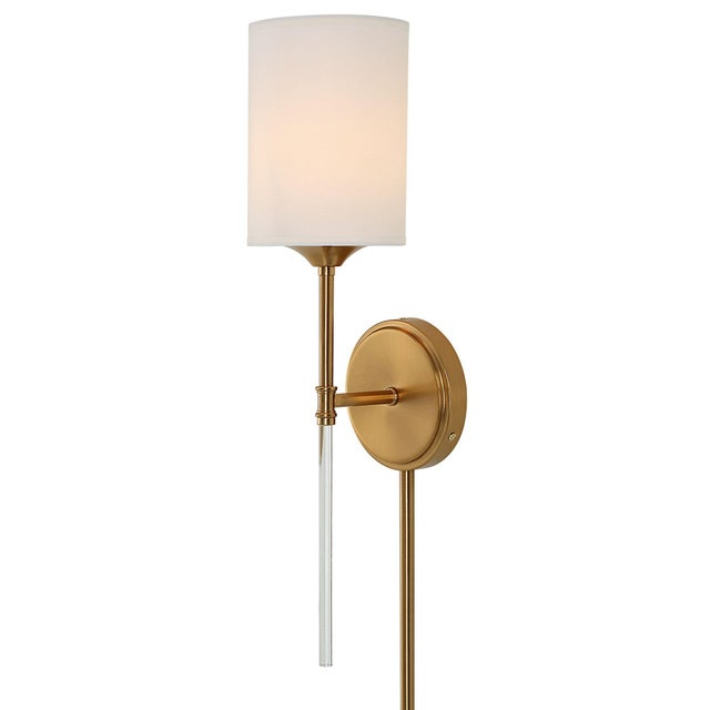 A traditional sconce in a warm brass finish modernized with a slender clear acrylic accents tall and white silken shade....