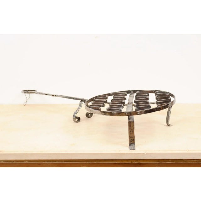A French iron grill from the 19th century, with petite feet and long handle. Created in France during the 19th century,...