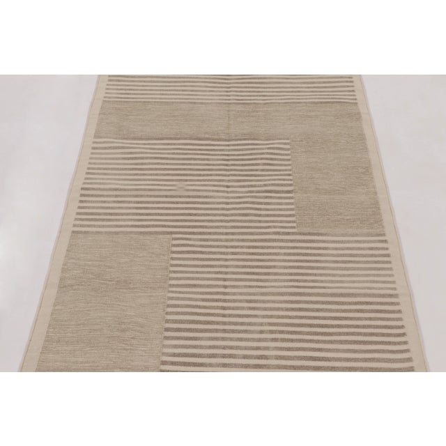 This modern 3 x 5 dhurrie rug from India features a refined geometric composition rendered in a soft, neutral palette....