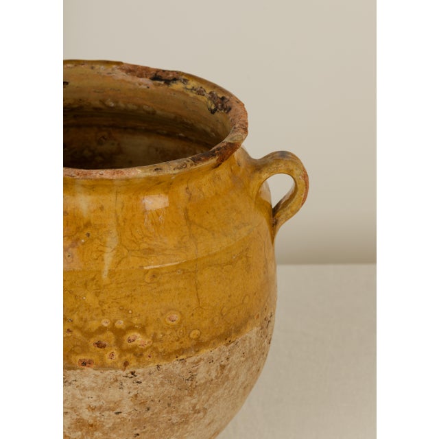 19th Century French Provincial confit pot with twin handles. Ochre yellow glazed upper half, unglazed terracotta lower body.