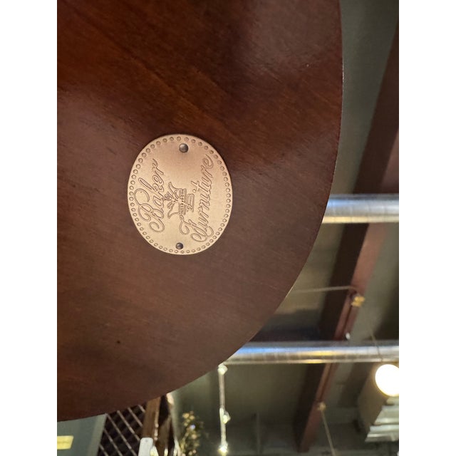 An elegant Williamsburg-style mahogany plant stand by Baker Furniture, featuring a refined pedestal form and a beautifully...