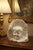 A sculpture depicting a child's face emerging from a block of marble. The contrast between the smooth face and the rough...