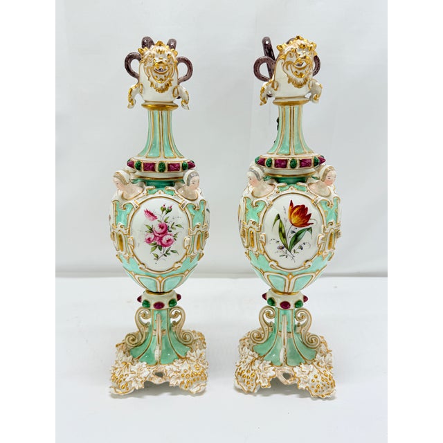 A rare and exceptionally elaborate pair of Meissen porcelain ewers, dating to the mid-19th century, executed in a richly...