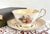 This vintage fine bone china teacup and saucer set was crafted by Paragon in Staffordshire, England. Molded into the...