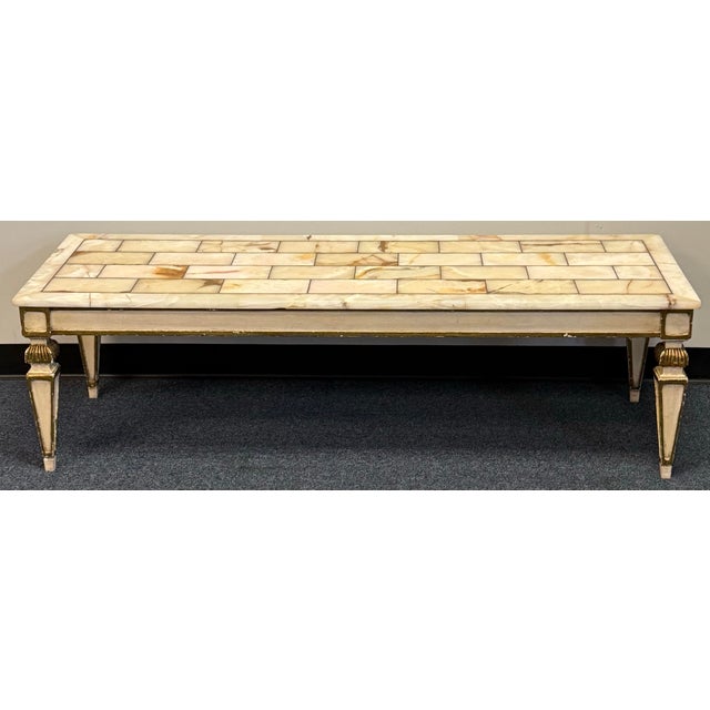 An elegant, generously sized coffee table featuring a translucent onyx top with warm amber veining. The stone is arranged...