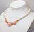 Circa 1990 goldtone faux-pearl beads with three pink resin flowers in middle with faux-pearls in their centers necklace...