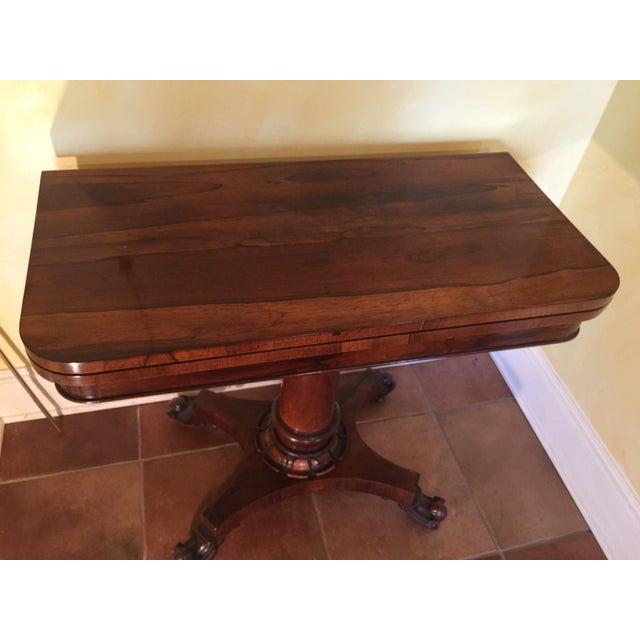 Phillip's Auction in London(1998) described this Regency game table as a rosewood turnover top card table on circular...