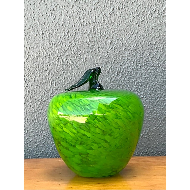 This vibrant vintage art glass apple is a striking example of hand-blown craftsmanship, echoing the celebrated techniques...