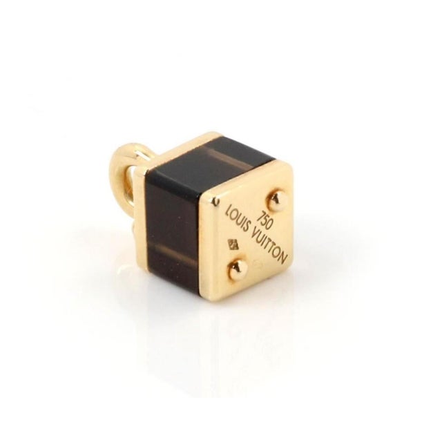 The Louis Vuitton Brown Cube Bag 18k Yellow Gold Charm Pendant is a luxurious and stylish accessory that features a...
