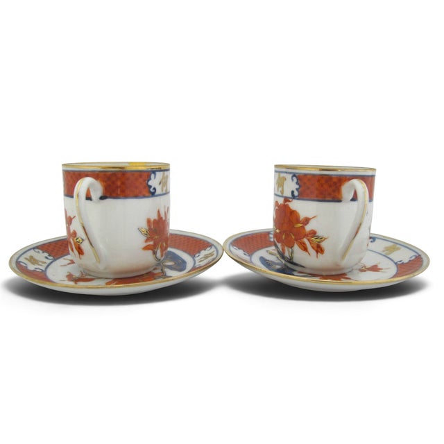 Beautiful pair of porcelain Asian demitasse cups with saucers. Each in white porcelain, with hand painted floral and...