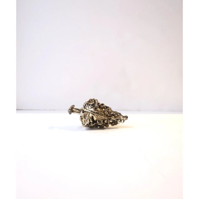 A beautiful sterling silver wine bottle stopper, handcrafted of grapes, vines, and leaves, circa mid to late-20th century....