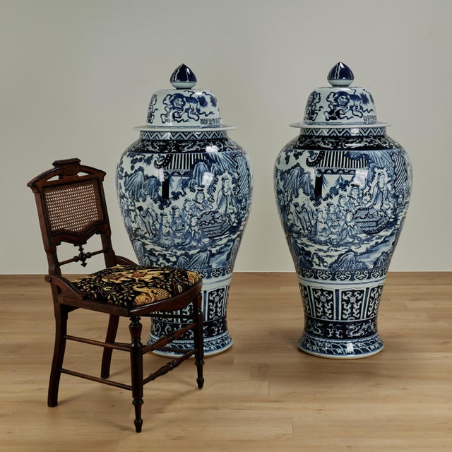 Impressive pair of Chinese porcelain blue and white lidded palace urns handcrafted in classic form with elaborate hand...