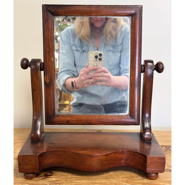 Antique rectangular pivoting shaving mirror attached to solid wood base. Four round feet to base. Age wear. Some...