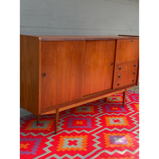 Stunning Danish teak highboard with rosewood accents combines beautiful craftsmanship with exceptional functionality. The...
