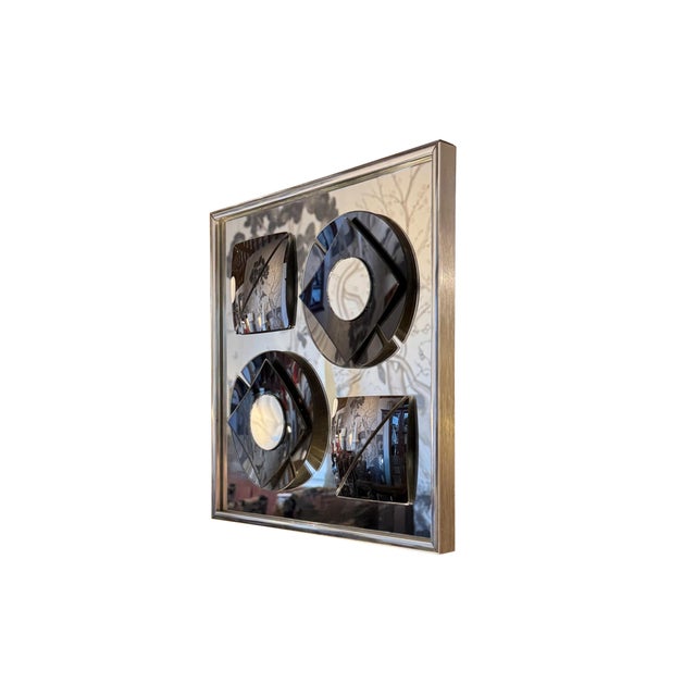 A striking Mid-Century Modern "Mirror Graphics" wall sculpture by Hal Bienenfeld. This sculptural mirror features four...