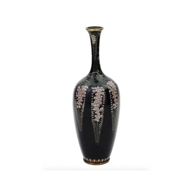 An antique Japanese, late Meiji period, enamel over brass vase. The vase has an amphora shaped body and a tall narrow...