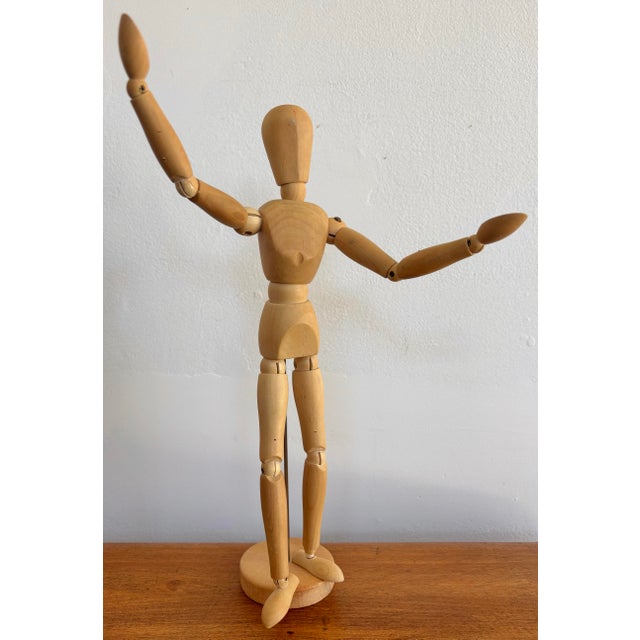 Wooden artist's posable figure on stand, features metal pins, bolts and sprung joints. The figure is attached to a stand...
