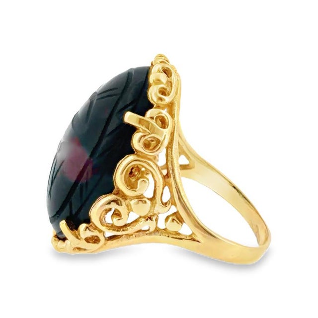 Crafted in 14k yellow gold, this statement ring features a cabochon-cut bloodstone with a scarab motif. The Egyptian...