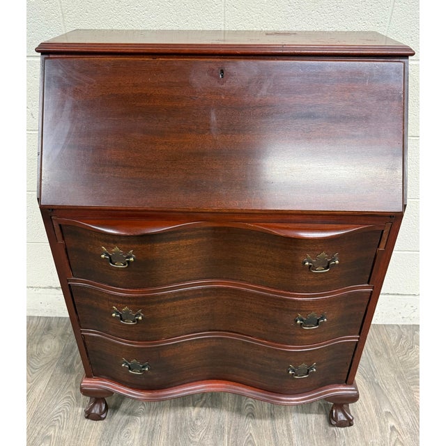 This is a vintage Chippendale-style mahogany secretary desk featuring a slant front, fall front, or drop front writing...