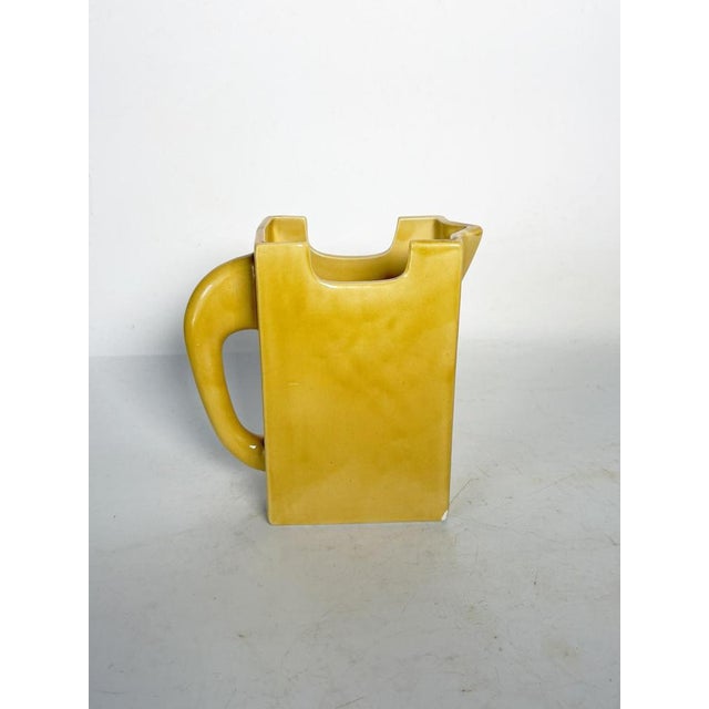 Yellow glazed ceramic pitcher, made in France circa 1970. Its geometric and architectural silhouette—rectangular body,...