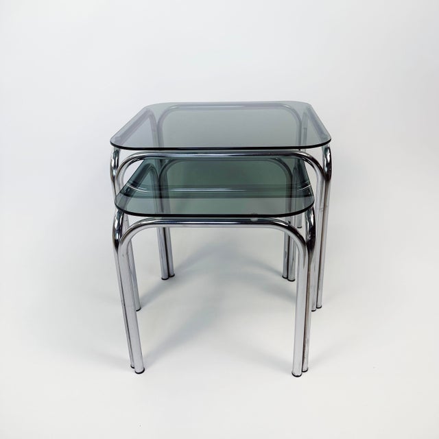 Add a touch of cool to your living room! this set of 2 nesting tables from the 1970s in smoked glass and chrome will do...