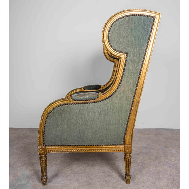 Charming antique French bergère. French Louis XVI giltwood wing armchair, leaf-moulded frame and outward roll of arms with...
