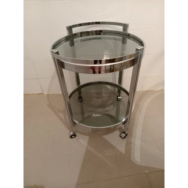 Round bar trolley in chromed metal, smoked glass.
