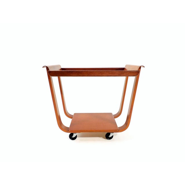 In 1954, the rare tea carriage model "PB01" resulted from curved birch plywood and massive oak. Swivel castors made of...