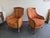 A beautiful pair of enveloping bergère armchairs, from a high-quality furniture manufacturer, bearing an elegant metal...