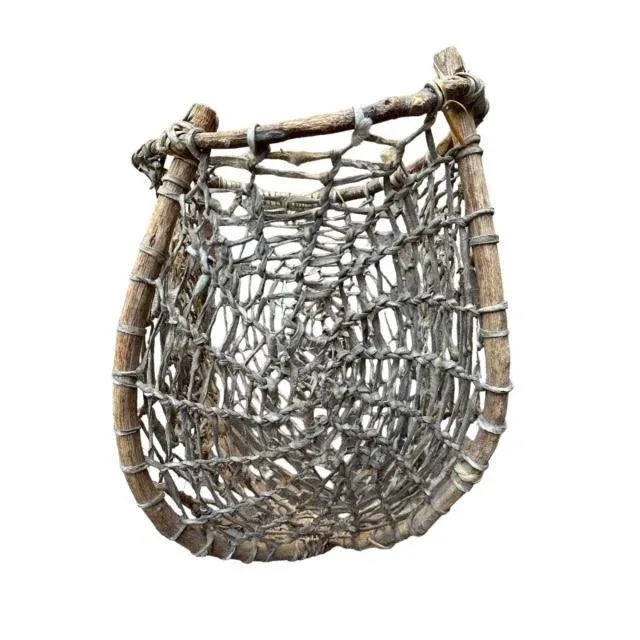 A 1940s Tarahumara rawhide and twig basket — a wall hanging of cowhide and wood from Mexico. Measures 14"W x 15"D x...