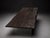 A modern live edge-style coffee table featuring a dark textured wood-look top and clear glass panel legs. The combination...