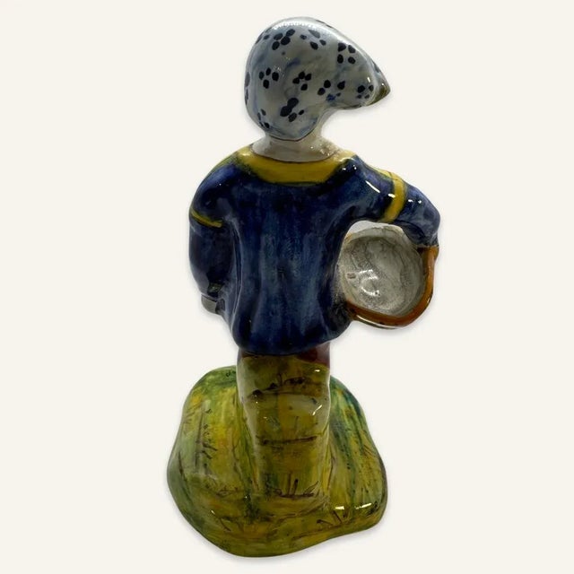 This little Quimper style figurine is painted in the usual colors found in this type of faience. The painting is primitive...
