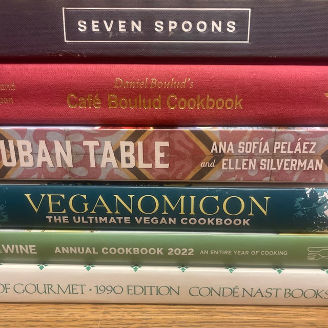 A bold yet refined decorative book vignette curated around iconic culinary voices, global flavors, and classic food...