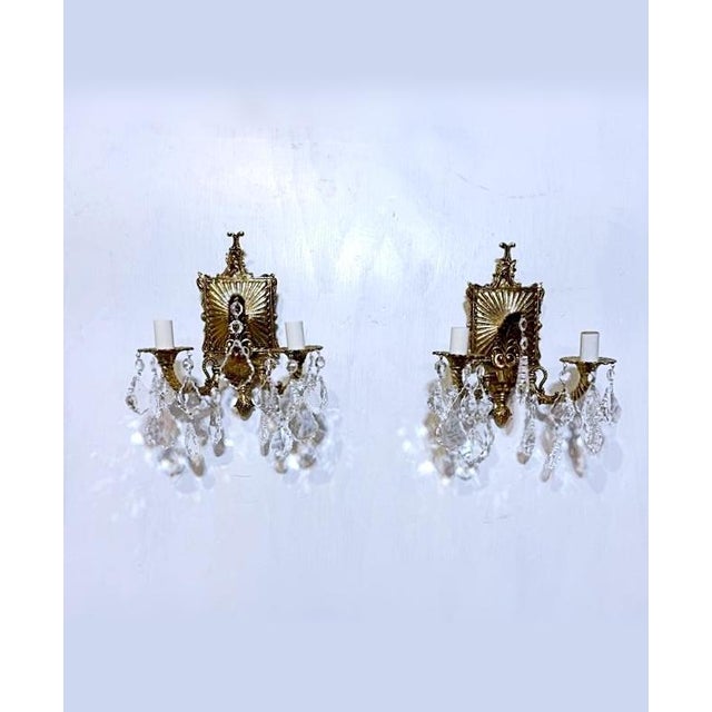 A striking pair of elaborate classic bronze sconces. The bronze frame is very decorative and dressed with pendeloque and...